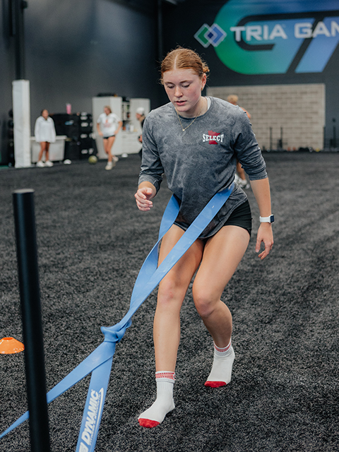 An athlete trains with resistance bands on the indoor turf.