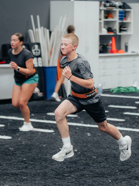 Young athletes race across the indoor turf.